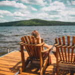 Kvinna som sitter i solstol på brygga