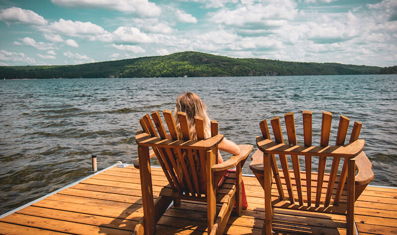 Kvinna som sitter i solstol på brygga