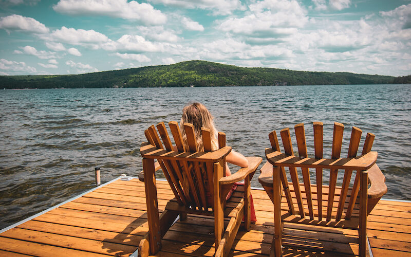 Kvinna som sitter i solstol på brygga