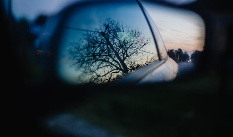 Träd som reflekteras i sidospeglarna på bil
