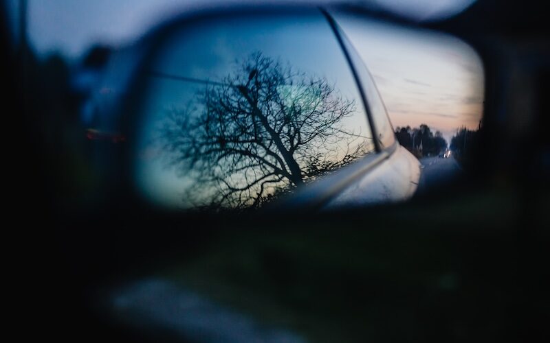 Träd som reflekteras i sidospeglarna på bil
